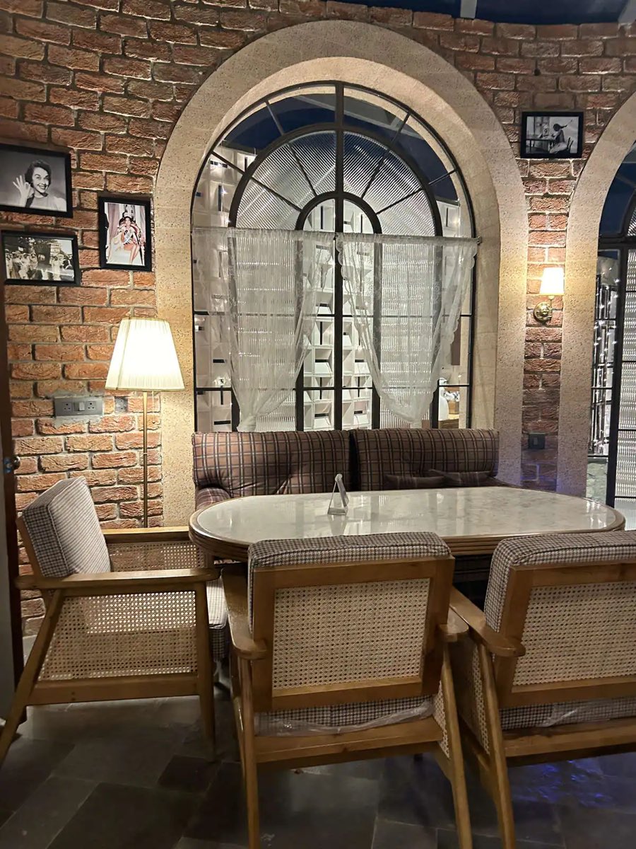 Brick arches and cane armchairs around a marble table