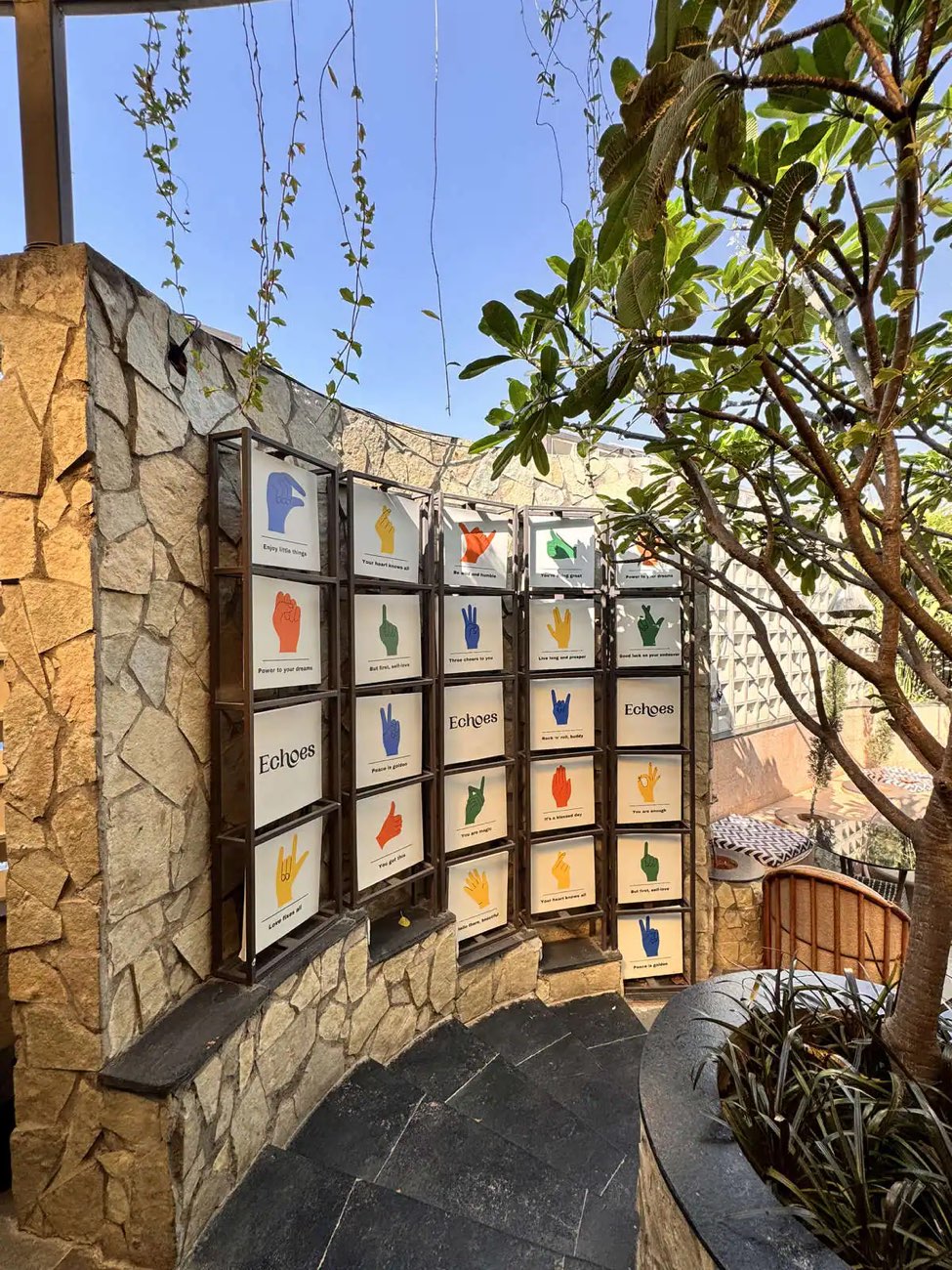 The Echoes sign wall — cards showing hand signs with phrases such as 'Enjoy little things' and 'Love fixes all'