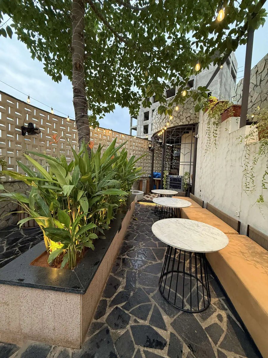 Marble café tables along a planter on the terrace